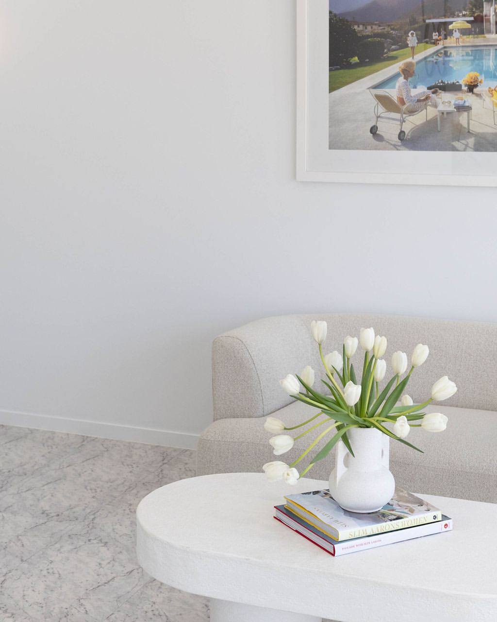 Boutique waiting area with a bouclé sofa, tulips and marble flooring