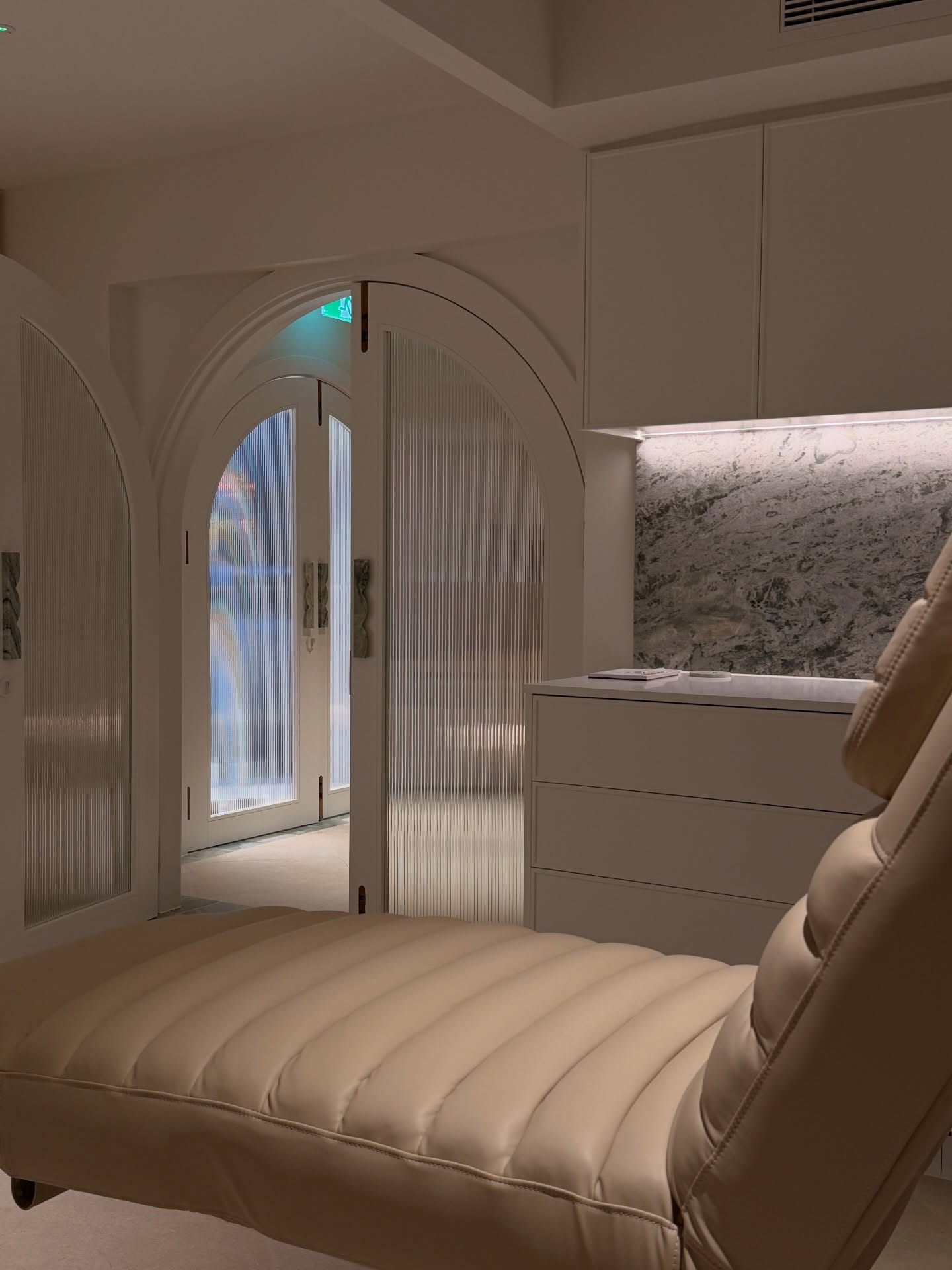 Treatment room with a cream reclining chair and marble detailing