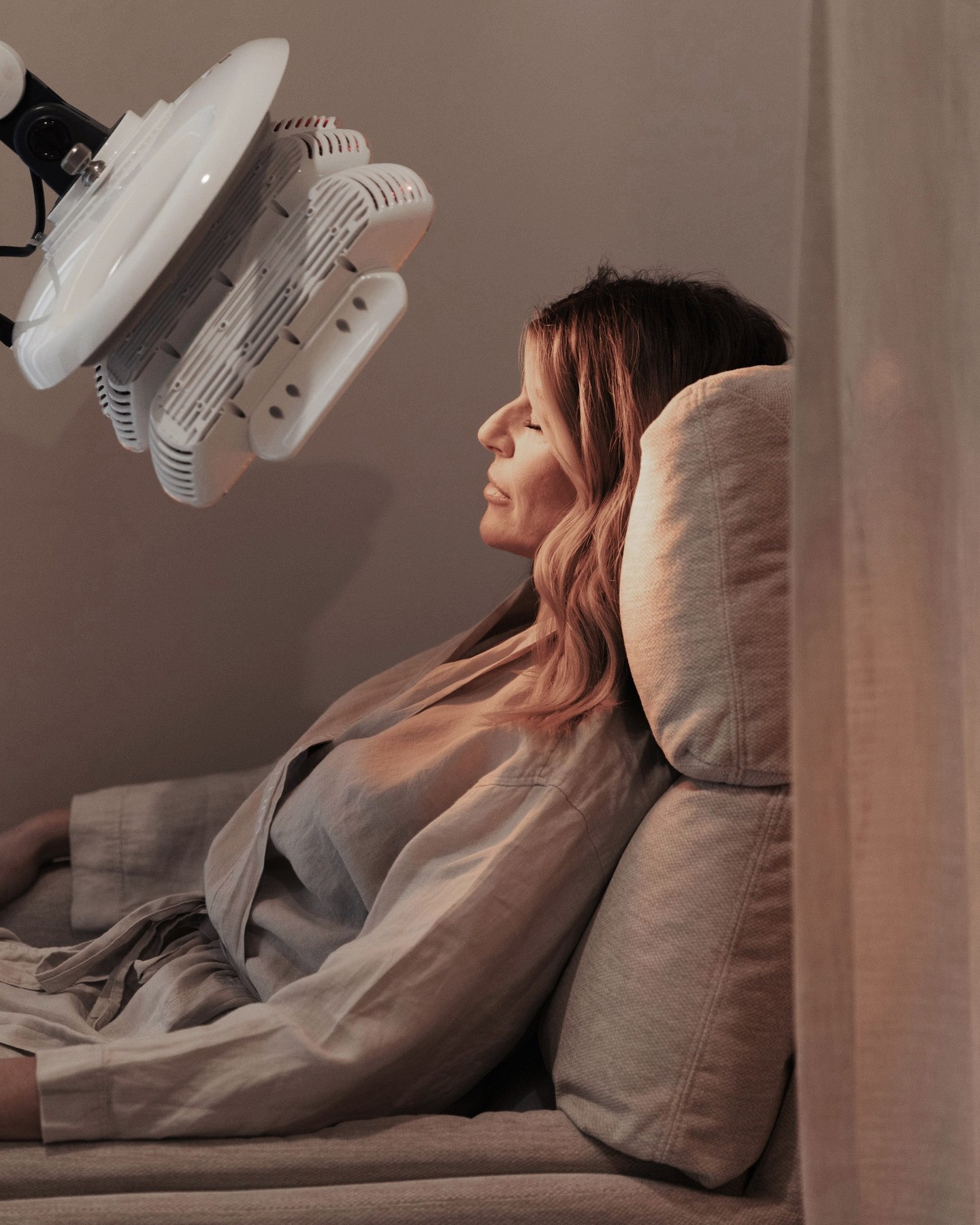 Client resting under an LED light therapy device at a Gold Coast skin clinic